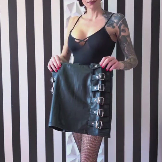 Black mini skirt. Crafted from PU leather and buckle details on both sides